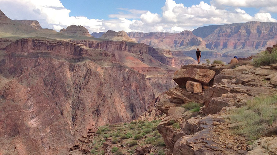A hiker posing on a rock formation in the Grand Canyon