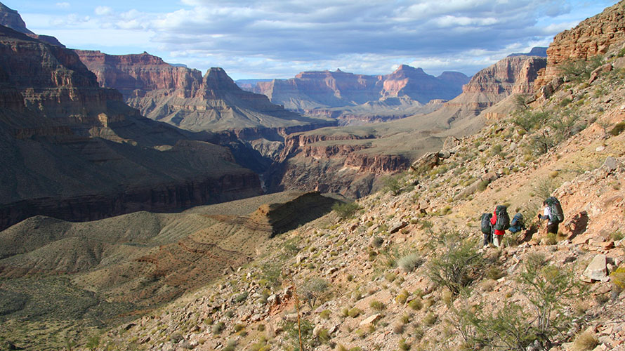 Hikers walking near a cliffside on the Hermit Trail