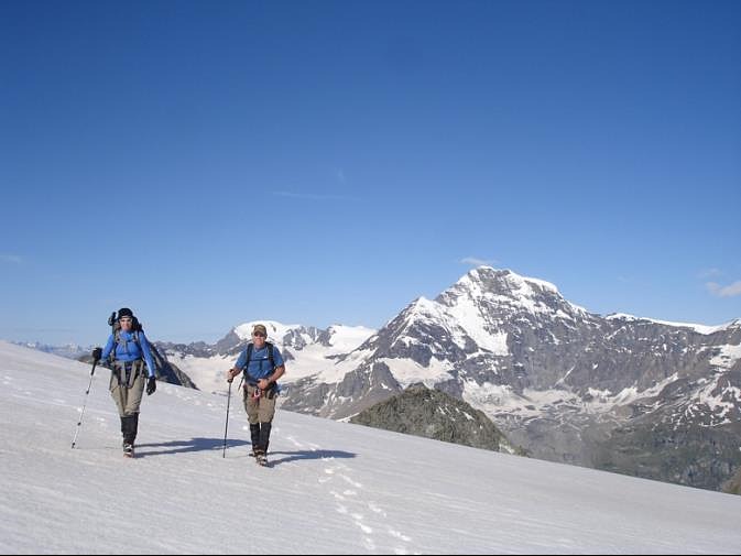 Two trekkers traversing steep glaciated terrain during the Haute Route Glacier Trek.