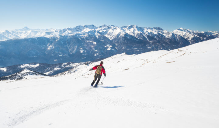 A skier on a slope near the mountain town of Courmayeur, Italian Alps.