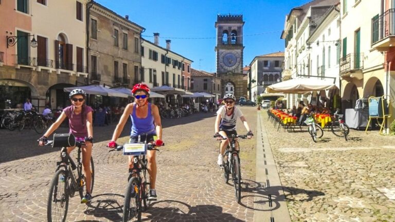 Three cyclists on a street of Italian town