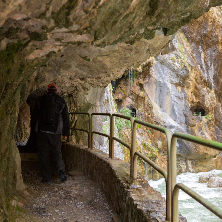 Hiker in a narrow tunnel in the Cares Gorge near Cain